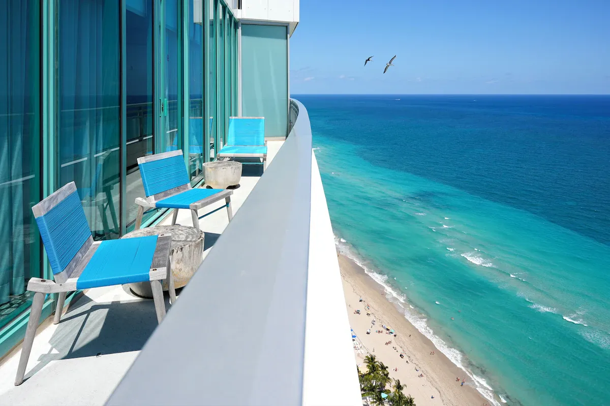 Oceanfront balcony at The Diplomat hotel with turquoise chairs overlooking the beach near Miami for 2026 World Cup visitors