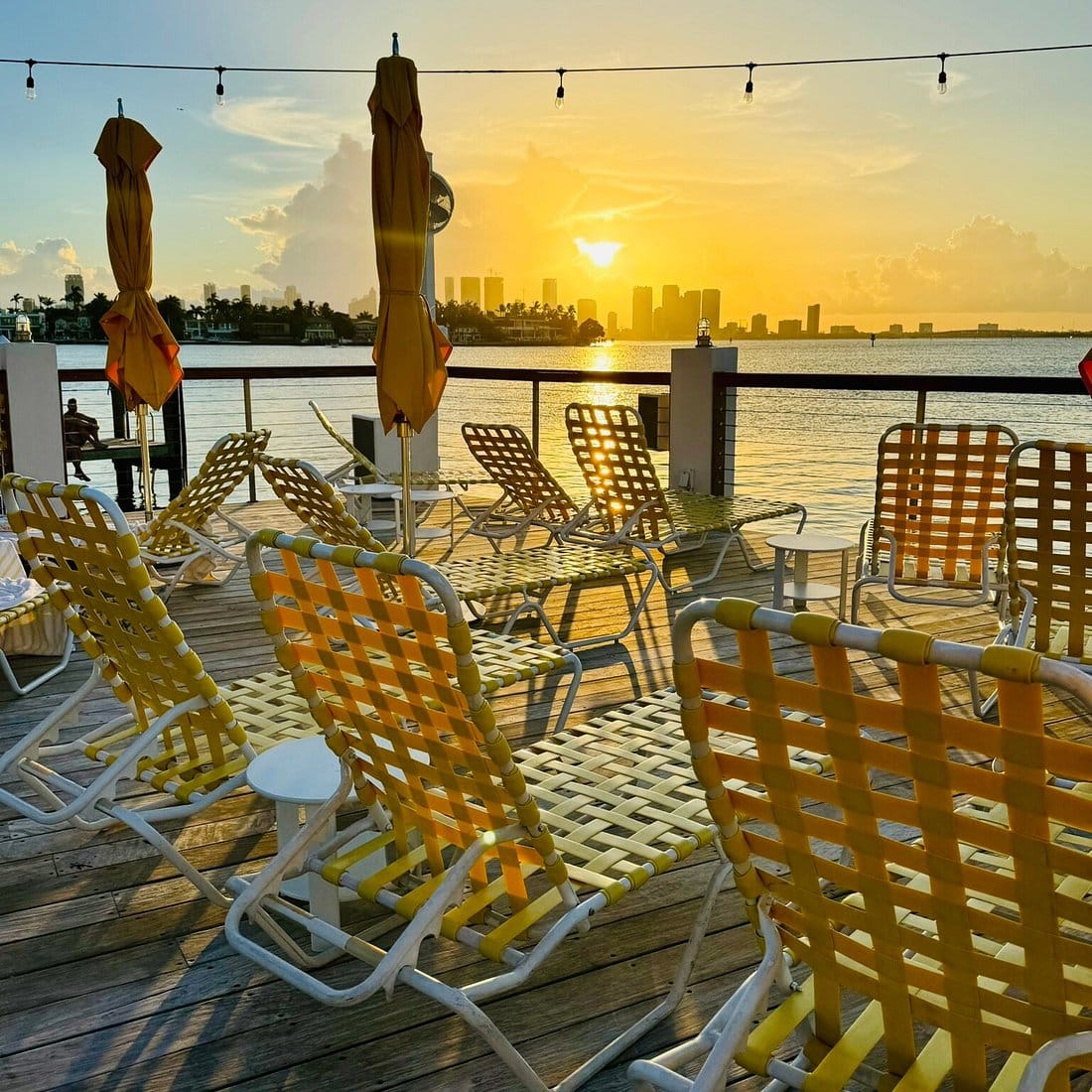 Sunset view from The Standard Miami bayfront deck with lounge chairs overlooking Biscayne Bay, a top luxury hotel for the Miami World Cup 2026.