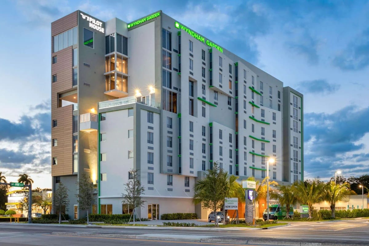 Exterior view of Wyndham Garden Miami International Airport highlighting free on-site parking and easy access near Miami International Airport for early morning flights.