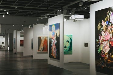 Contemporary art gallery installation at Art Basel Miami Beach with visitors exploring exhibits