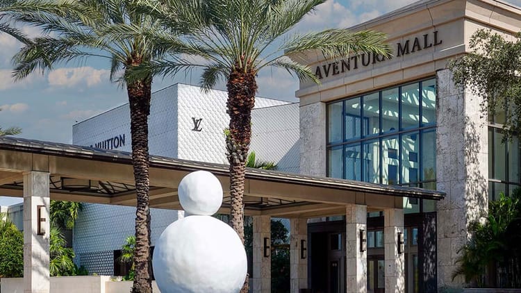 Aventura Mall main entrance with palm trees in Aventura, Miami, Florida — luxury shopping destination near Sunny Isles Beach