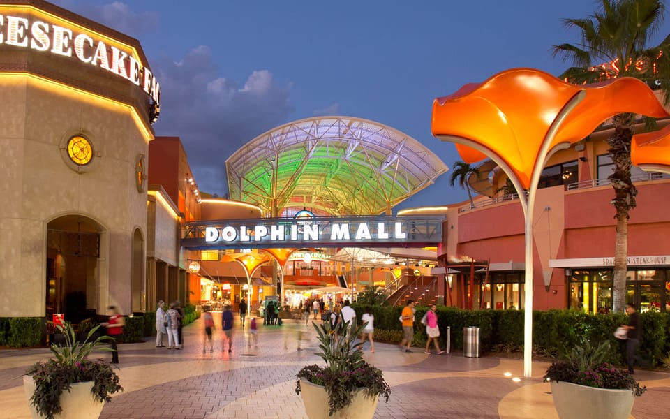 Entrada principal de Dolphin Mall en Miami de noche, centro comercial cerca de los mejores hoteles en Doral